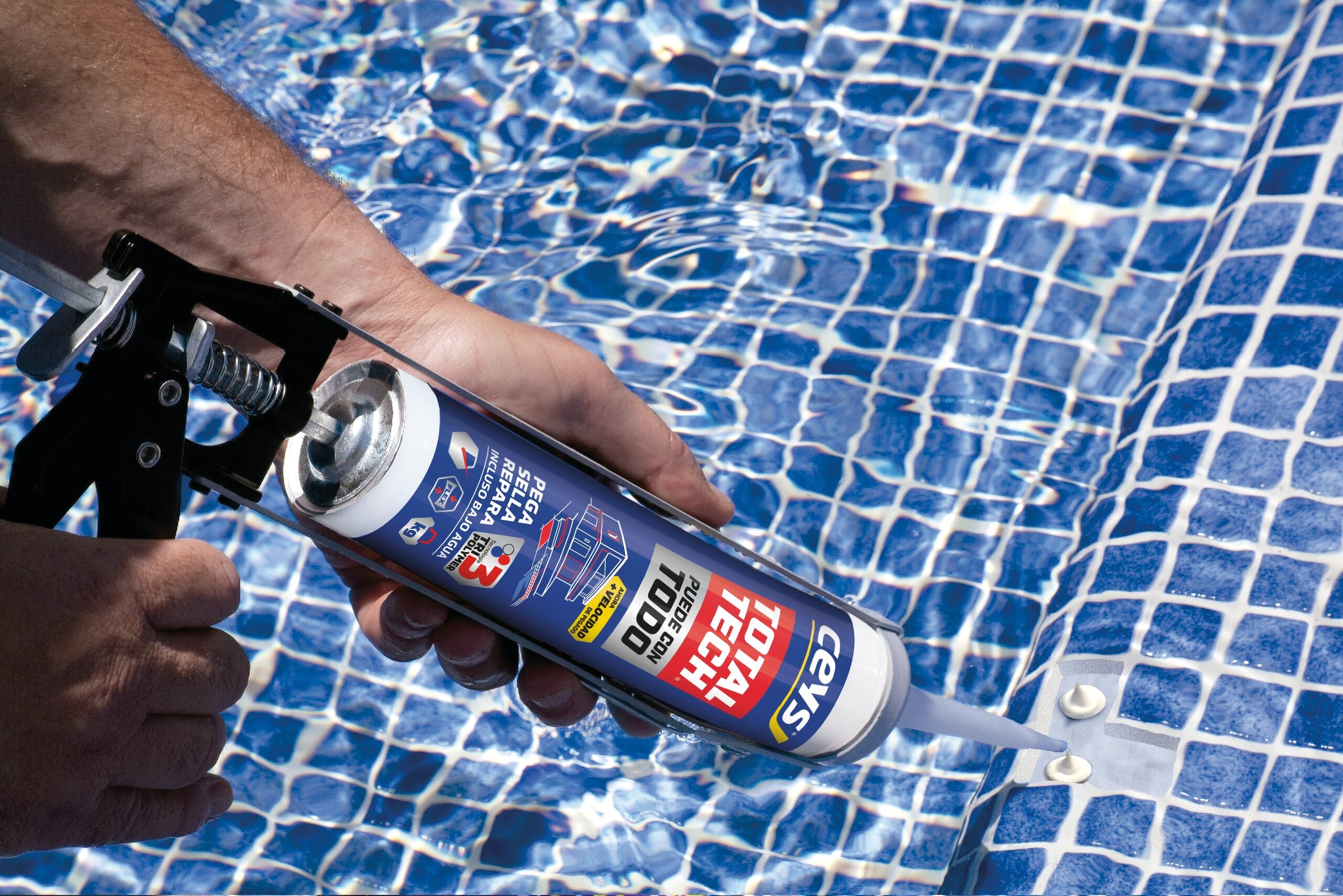 Persona aplicando el adhesivo-sellador TotalTech donde se ha desprendido el gresite dentro de una piscina.